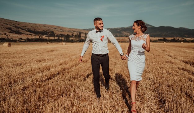 una joven pareja casada en un gran campo disfruta de la puesta de sol. Enfoque selectivo. foto de alta calidad