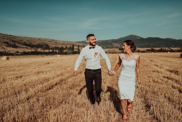 una joven pareja casada en un gran campo disfruta de la puesta de sol. Enfoque selectivo. foto de alta calidad