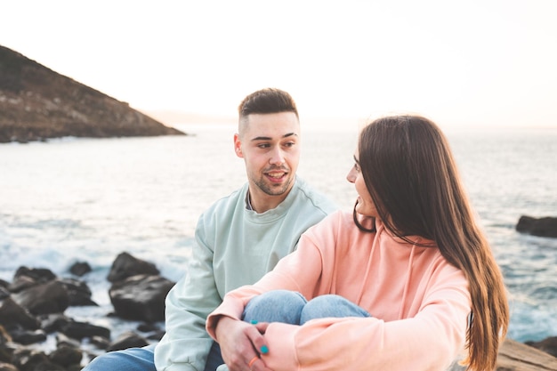 Joven pareja caucásica charlando al lado del mar