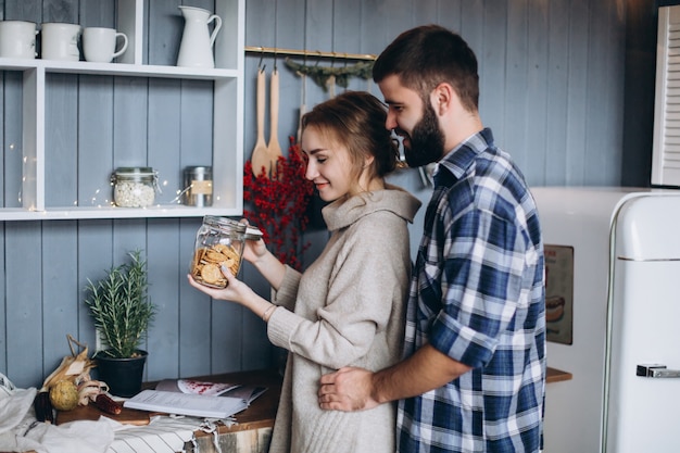 Joven pareja caucásica con estilo de cocina, abrazos en la acogedora cocina moderna. Felicidad, libertad, concepto de familia.