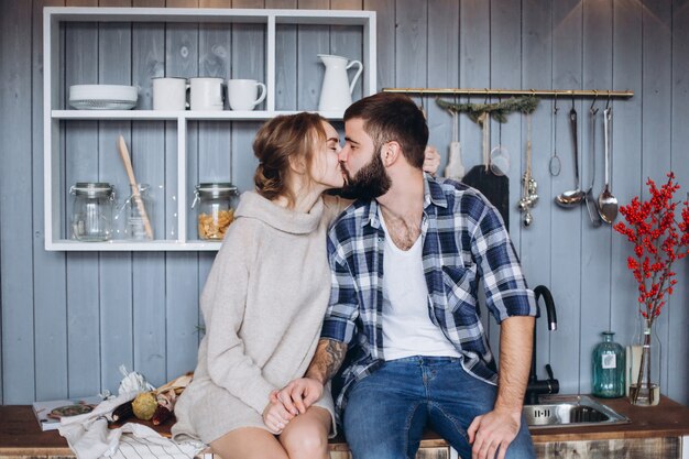 Joven pareja caucásica con estilo de cocina, abrazos en la acogedora cocina moderna. Felicidad, libertad, concepto de familia.