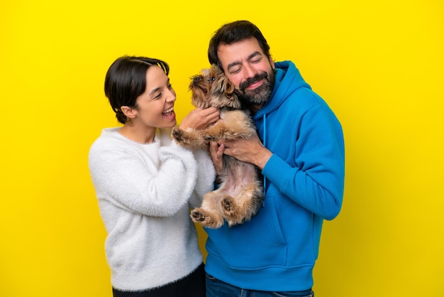 Joven pareja caucásica sosteniendo un perro