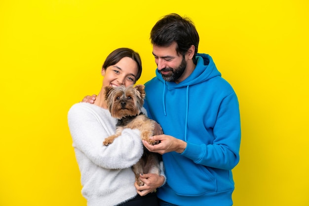 Joven pareja caucásica sosteniendo un perro