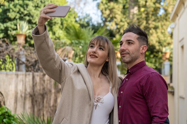 Joven pareja caucásica tomando un selfie con el smartphone