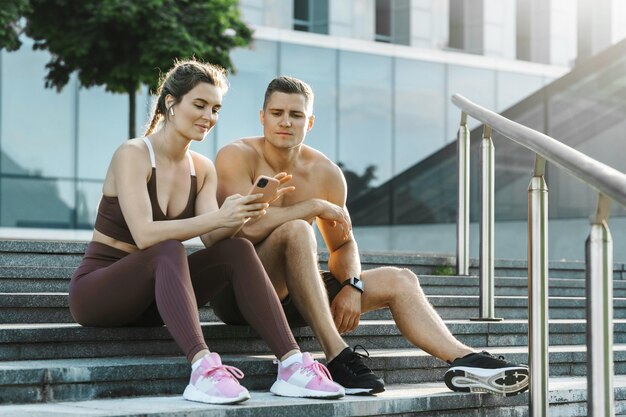 Joven pareja deportiva relajante después de hacer ejercicio físico al aire libre
