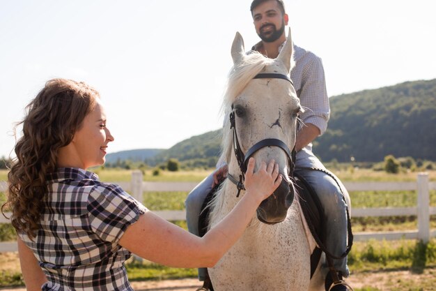 La joven pareja descansa en una granja de caballos.