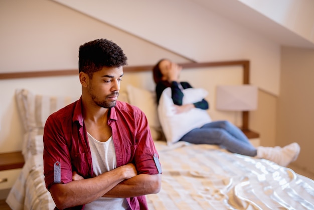 Joven pareja después de pelear. chica está llorando en la cama.