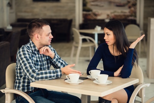 Joven pareja discutiendo en un café