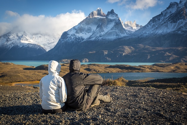 Foto joven pareja disfrutando de un hermoso escenario en torres del paine.