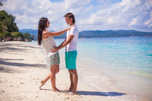 Joven pareja disfrutando de sus vacaciones y divertirse en una playa tropical