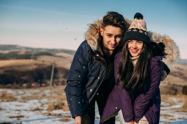 Joven pareja se divierten en la nieve