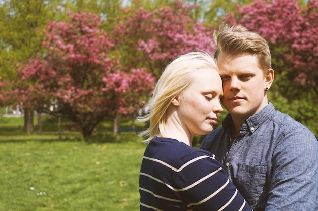 Una joven pareja enamorada abrazándose en la naturaleza.