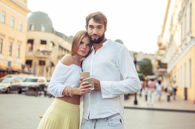 Foto una joven pareja enamorada bebiendo café en la ciudad.