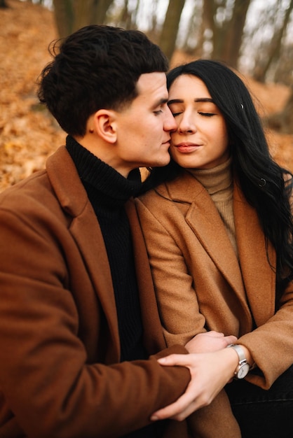 Una joven pareja enamorada caminando en el parque en un día de otoño disfrutando del tiempo juntos.