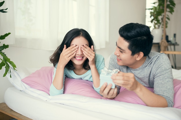 Joven pareja enamorada se hace un regalo el día de San Valentín.