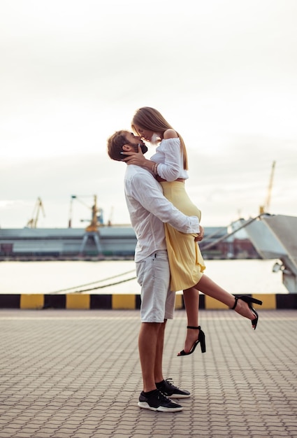 Foto joven pareja enamorada hombre y mujer besándose en el puerto concepto de amor romántico