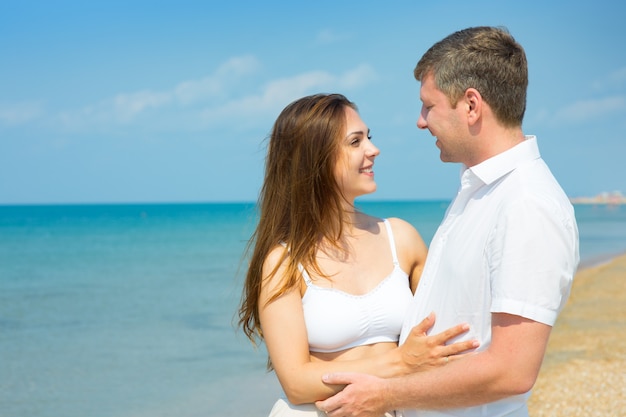 Una joven pareja enamorada en la playa.