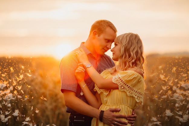 Joven pareja de enamorados al aire libre. Están sonriendo y mirándose el uno al otro.