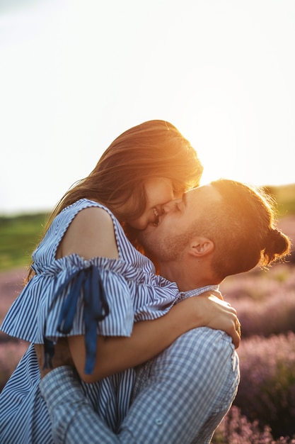 Joven pareja de enamorados al aire libre. Impresionante sensual retrato al aire libre de moda joven posando de moda joven durante el verano en el campo con puesta de sol