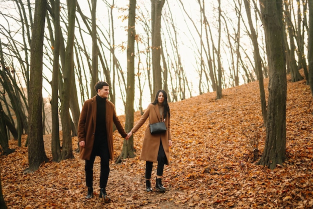 Foto joven pareja de enamorados caminando en el parque en un día de otoño