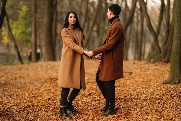 Joven pareja de enamorados caminando en el parque en un día de otoño