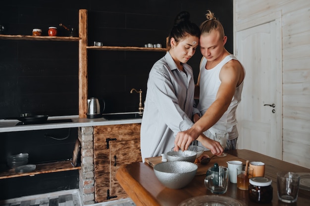 Joven pareja de enamorados cocinar juntos en la cocina comida sana