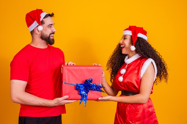 Joven pareja de enamorados intercambiando regalos en Navidad. Feliz Navidad