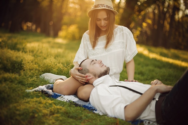 Joven pareja de enamorados en un picnic Hombre y mujer felices en el césped en el parque