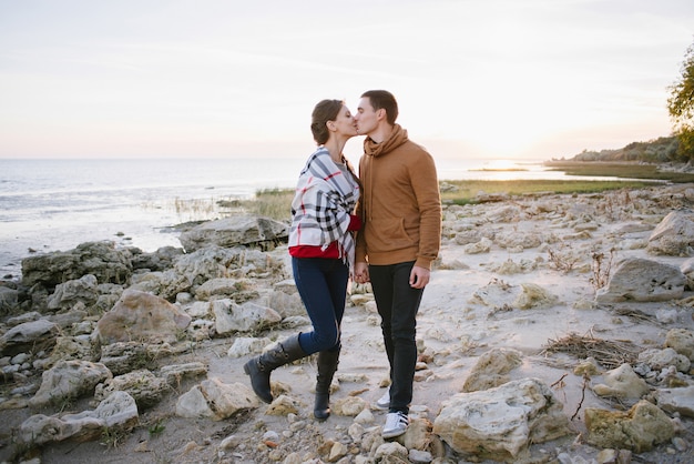 Joven pareja de enamorados en una playa rocosa