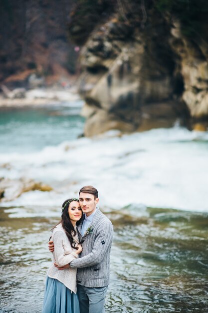 Joven pareja de enamorados en un río de montaña en los Cárpatos