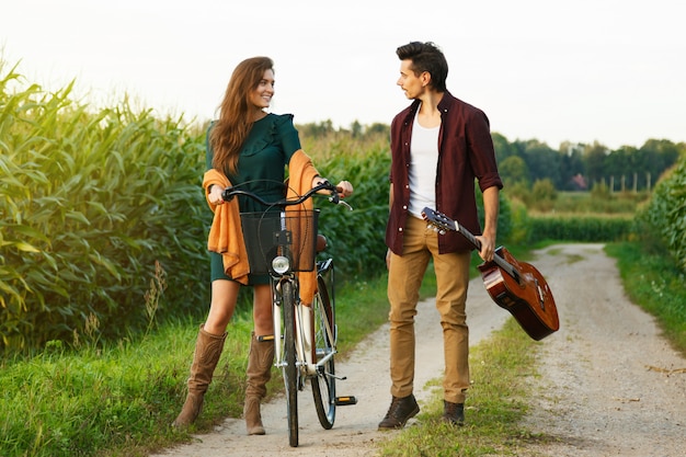 Joven pareja está caminando por camino rural