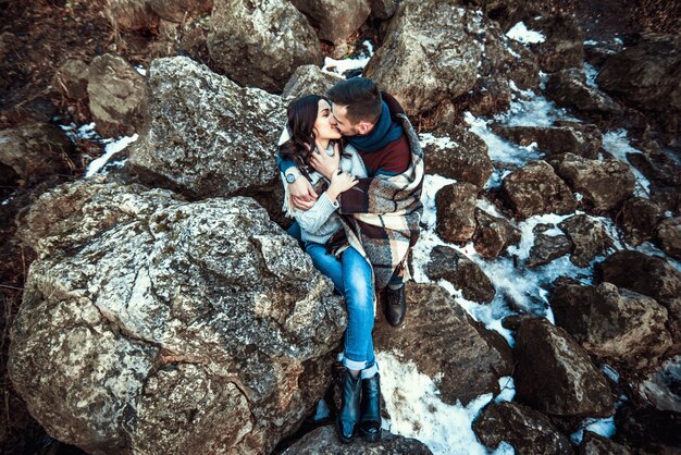 Joven pareja feliz al aire libre en las piedras