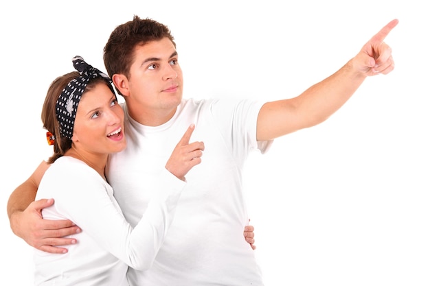 Foto una joven pareja feliz apuntando a algo contra el fondo blanco.