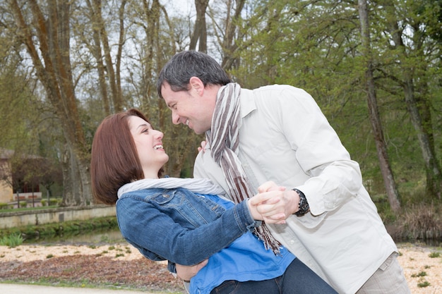 Joven pareja feliz bailando al aire libre