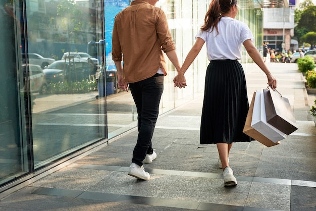 Joven pareja feliz con bolsas de compras en la ciudad.