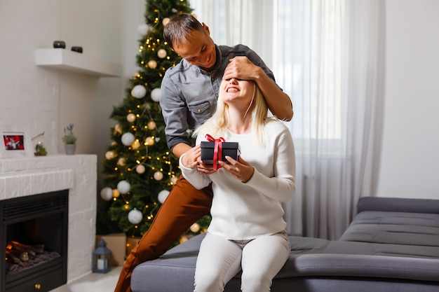 Joven pareja feliz cerca de un árbol de Navidad