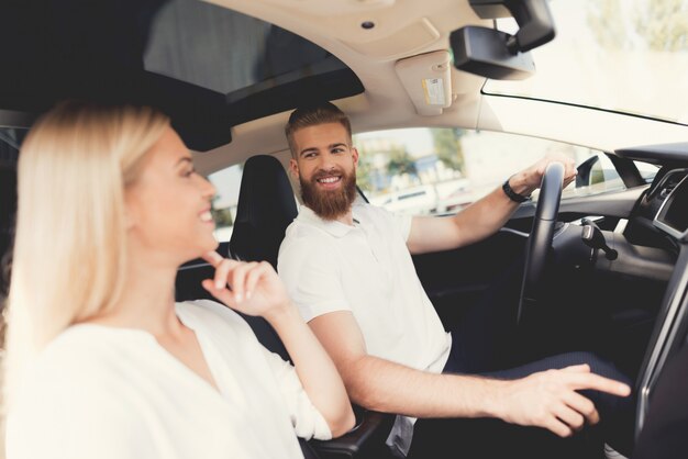 Joven pareja feliz en coche moderno juntos