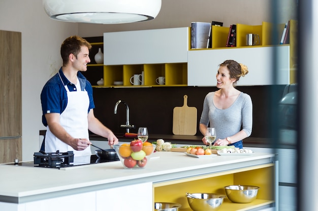 Joven pareja feliz cocinar juntos en la cocina en casa.