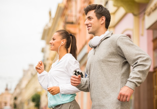 Joven pareja feliz corriendo al aire libre.