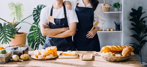 Joven pareja feliz disfruta y prepara comida saludable en su cocina y lee recetas en la computadora portátil