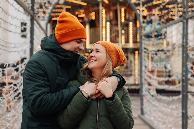 Joven pareja feliz divirtiéndose juntos en un mercado de Navidad