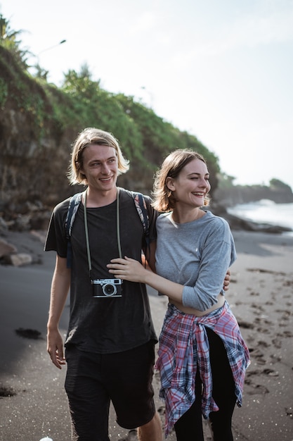 Joven pareja feliz divirtiéndose en la playa