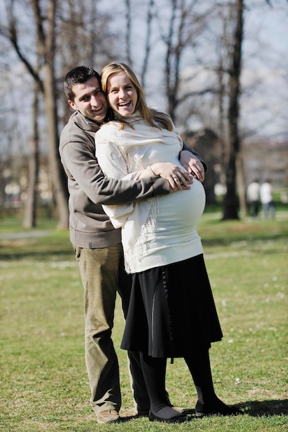 joven pareja feliz de familia casada al aire libre en la naturaleza se divierten y esperan al bebé y representan el crecimiento de la familia joven y el concepto de embarazo