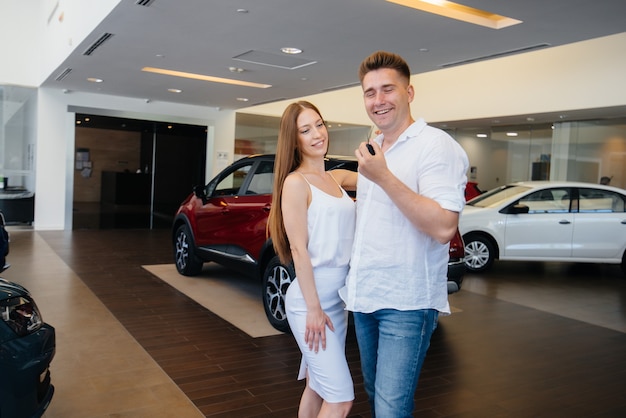Joven pareja feliz feliz de comprar un coche nuevo