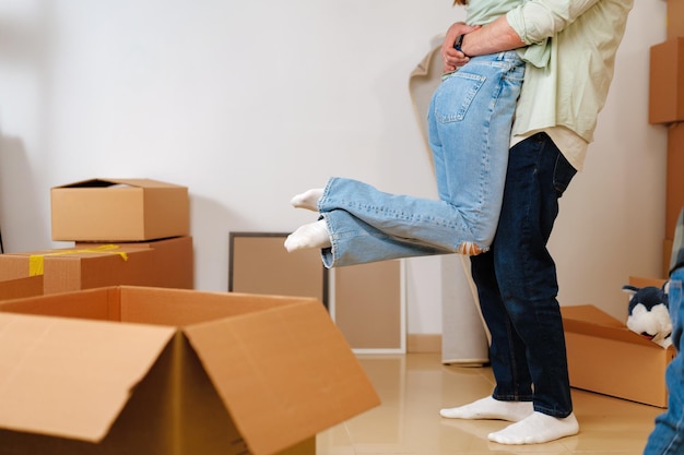 Joven pareja feliz en la habitación con muchas cajas de mudanza