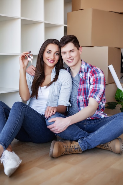 Joven pareja feliz mudarse a su nuevo hogar.