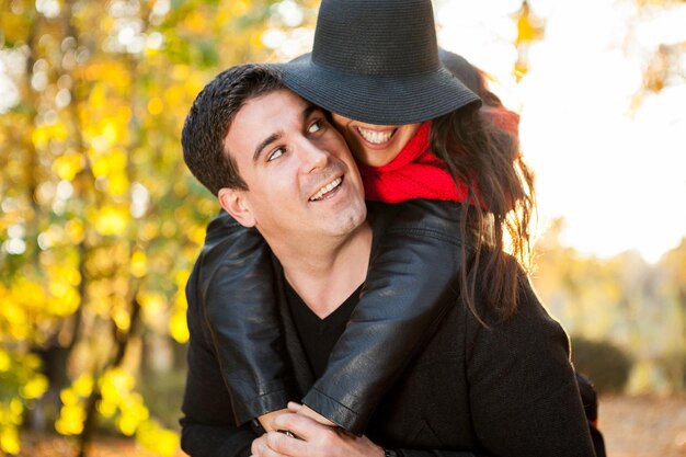 Joven pareja feliz en el parque divirtiéndose