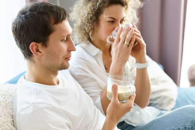 Joven pareja feliz pasar tiempo juntos y tomar café en casa