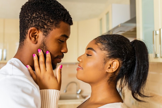 Joven pareja feliz de raza mixta pasando su tiempo en casa en la cocina