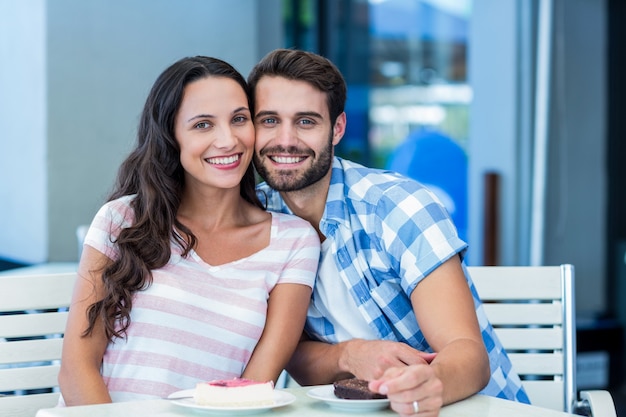 Joven pareja feliz sonriendo a la cámara